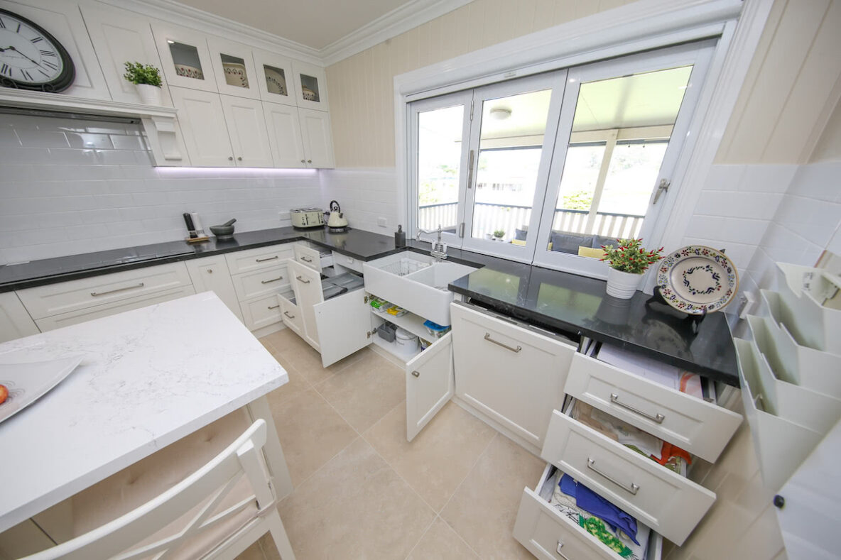 open white cabinetry in Hampton kitchen showing built in bin and dishwasher